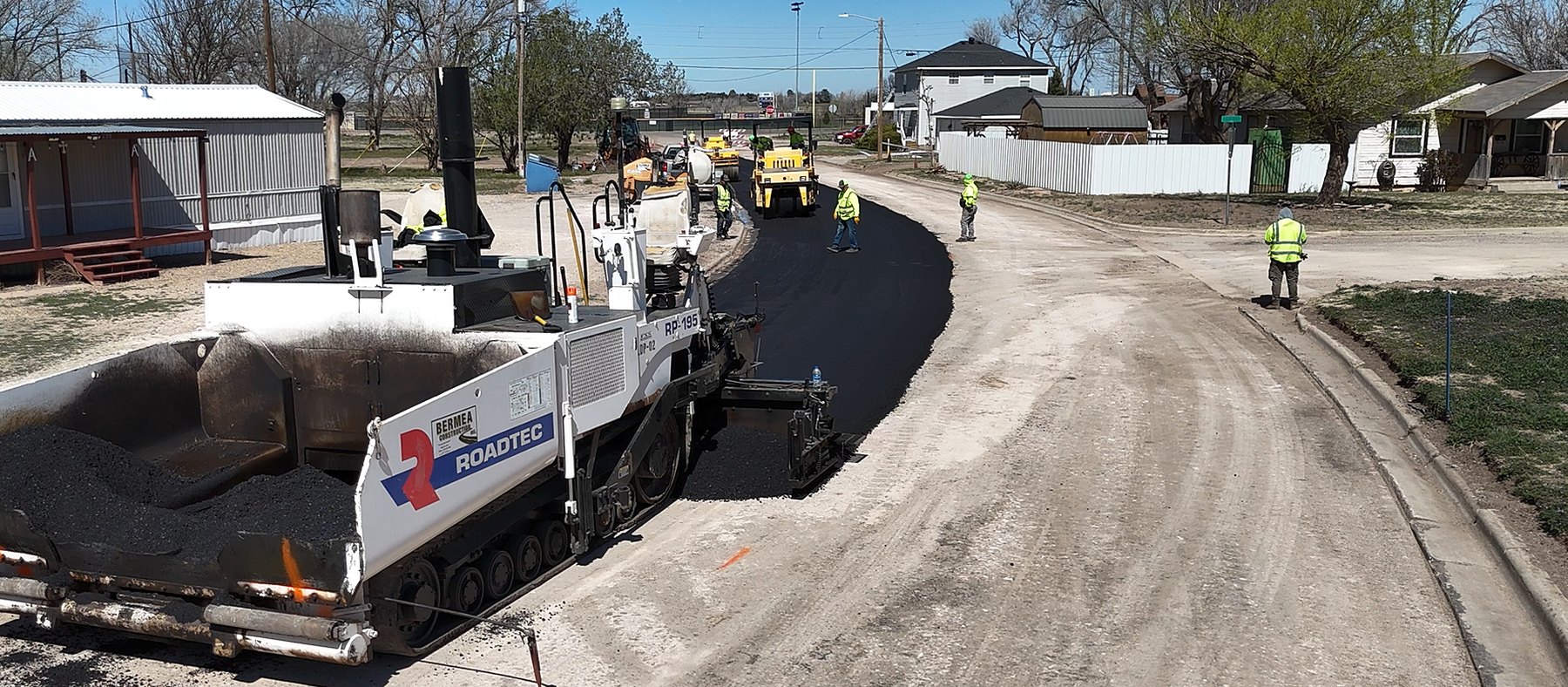 Bermea Construction paving crew placing hot mix asphalt on a street