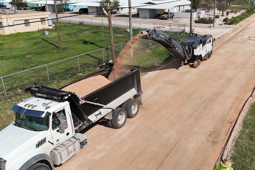 Cold planer and haul truck working a road down to a clean profile